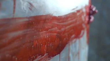 Yakın plan. Kurbanın kanlı elleri köşenin kenarına tutunmuş.