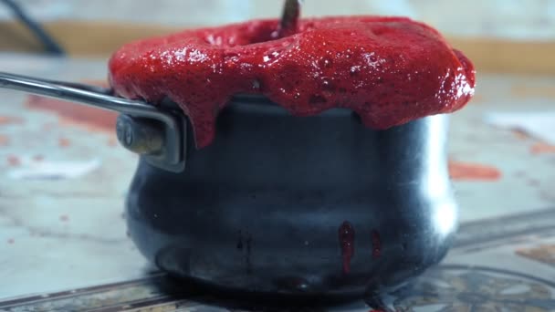Rood schuim giet uit de pan. bessensiroop maken — Stockvideo