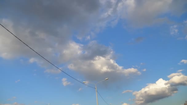 Luces de carretera en el fondo del cielo azul desde la ventana de un coche en movimiento — Vídeos de Stock