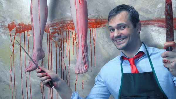 Man with a knife on the background of the bloody walls and the hanging legs — Stock Photo, Image