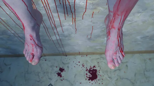 Yakın plan. Kanlı bir duvarın arkasında asılı bir adamın kanlı bacakları. — Stok fotoğraf