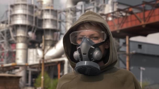 Retrato de una mujer en un respirador sobre el fondo de las chimeneas de fábrica — Vídeos de Stock