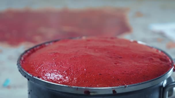 Czerwona piana wylewa się z patelni. produkcja syropu jagodowego — Wideo stockowe