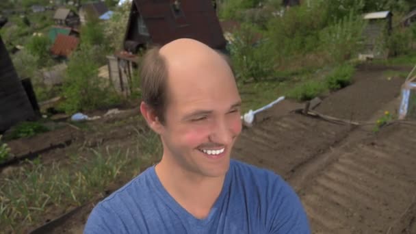 Portret, łysy młodzieniec na wsi patrzący w kamerę, uśmiechający się — Wideo stockowe