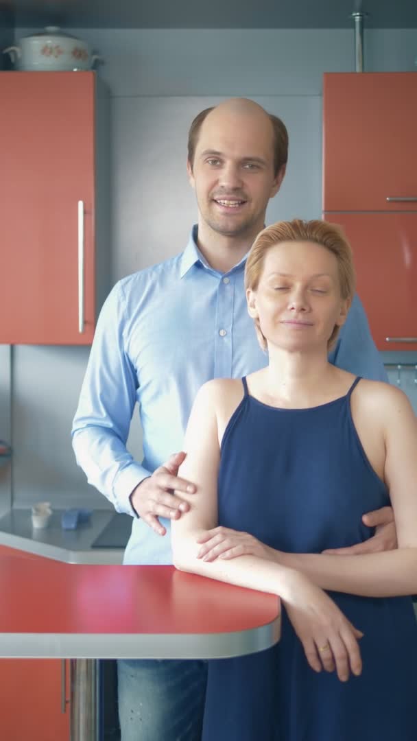 Verticalmente. marido e mulher olhando para a câmera enquanto em pé na cozinha — Vídeo de Stock