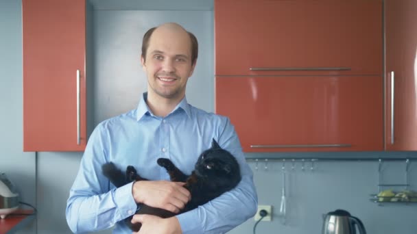 Retrato. hombre calvo solitario en una camisa con un gato en casa — Vídeos de Stock