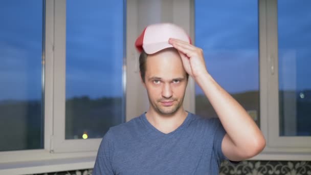 Hezký mladý plešatý muž nasadí čepici, zavírá holou hlavu — Stock video