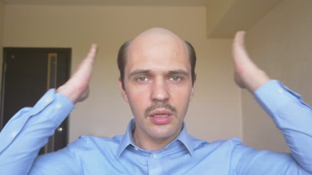 Όμορφος φαλακρός άντρας με μουστάκι θαυμάζει τον εαυτό του, ισιώνει τα μαλλιά του — Αρχείο Βίντεο