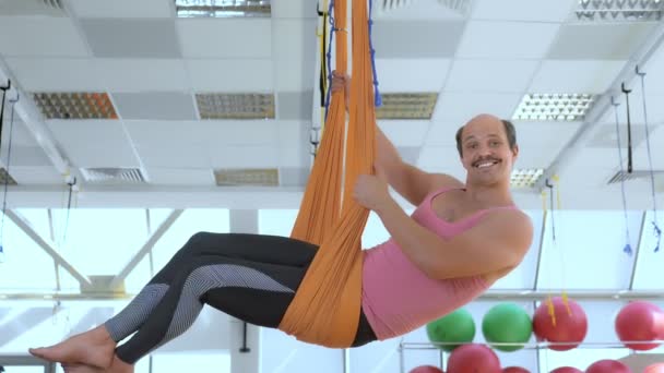 快乐的，微笑的秃头男子在空中瑜伽课的吊床上. — 图库视频影像