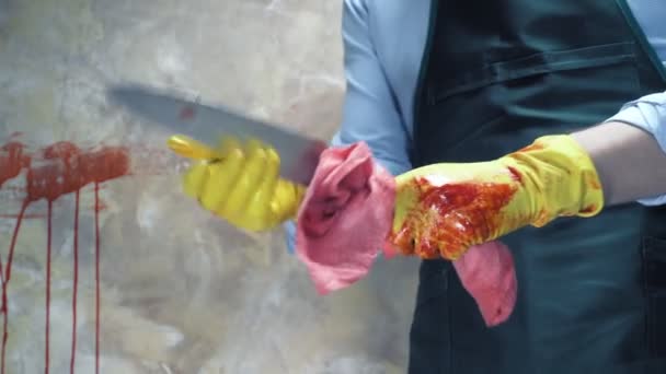 Крупний план. чоловічі руки в гумових рукавичках миють лезо ножа з крові — стокове відео