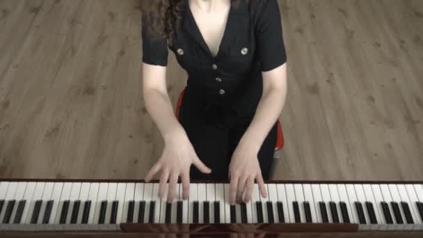 Menina bonita em óculos com cabelo encaracolado toca piano. vista frontal — Vídeo de Stock