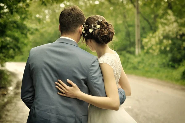 Bride and groom looking towards the upcoming road of their life — Stock Photo, Image