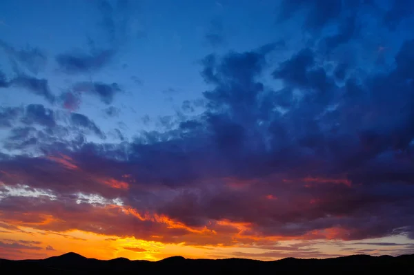 Sonnenuntergang mit Wolken, in orange und lila Tönen — Stockfoto