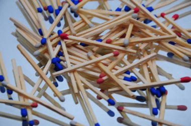 Ahşap kibritlerin arka planı aynalı bir masaya saçılmış, çok renkli, mavi kırmızı, tasarımcılar için makro fotoğraf.