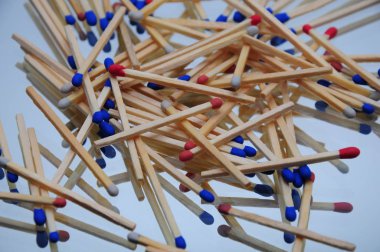 Ahşap kibritlerin arka planı aynalı bir masaya saçılmış, çok renkli, mavi kırmızı, tasarımcılar için makro fotoğraf.