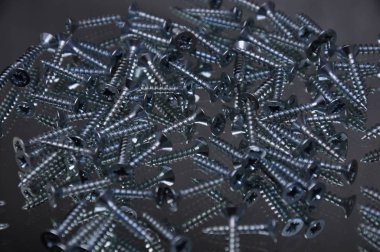 Aletler, kırmızı arka planda paslanmaz vidalar, işçiler ve ekran koruyucusu üretimi için