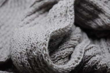 Ekran koruyucu veya arka plan için gri örülmüş bir eşarbın yakın çekimi. Sıcaktır, rahatlatır ve ısıtır.