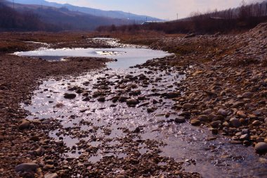 Öğleden sonra deniz kıyıları dalgalar ve su sıçramalarıyla, deniz kıyıları taşlarla.