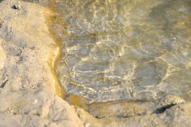 Öğleden sonra deniz kıyıları dalgalar ve su sıçramalarıyla, deniz kıyıları taşlarla.