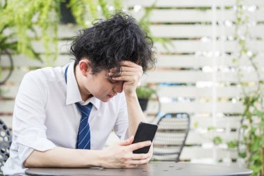 Hüsrana uğramış Asyalı genç iş adamı umutsuz iş problemleri konseptinde başarısız oldu.