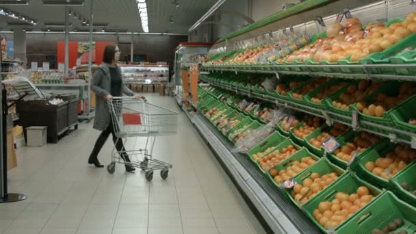 Uma jovem mulher visitando o supermercado — Vídeo de Stock