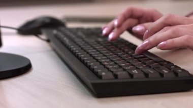 Kadın parmakları klavyede çalışıyor. Kadın ofiste çalışıyor..