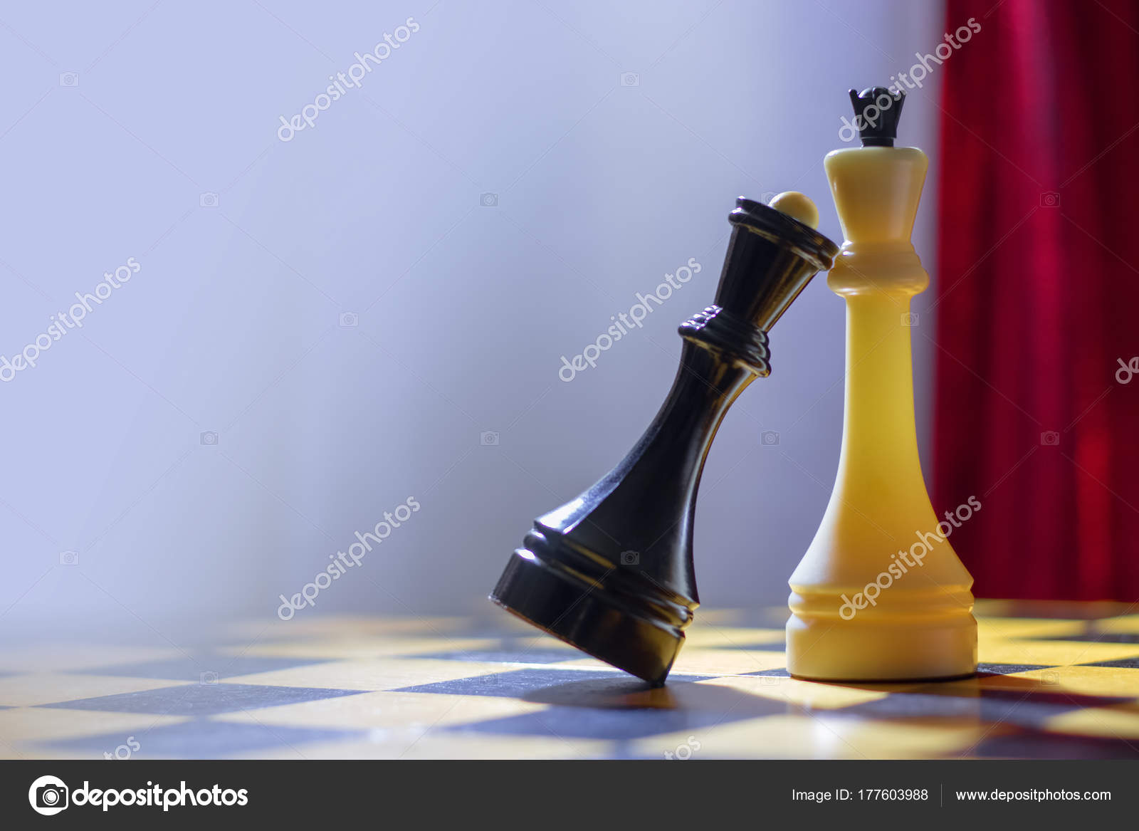 Chess black queen and white king stand on a chessboard stock photo