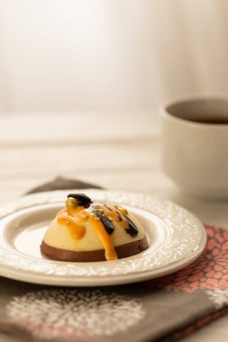 Bir fincan kahve ve beyaz ahşap masada tatlı bir pastayla sakin bir hayat. Sabah güneşinde kahvaltı.