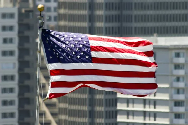 Close up de moscas bandeira americana no fundo de arranha-céus — Fotografia de Stock