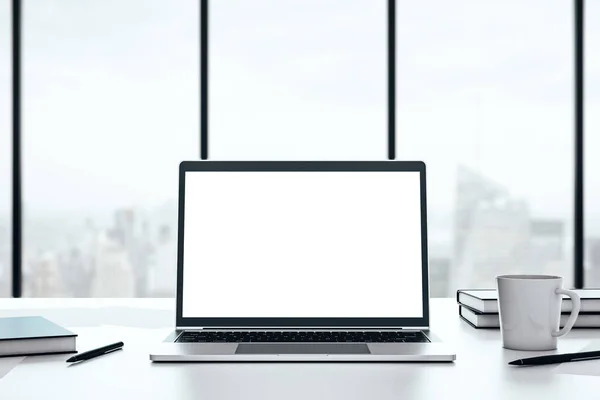 Laptop dengan layar putih kosong pada desktop pada latar belakang jendela besar dengan tampilan kota, mockup. Perenderan 3D — Stok Foto