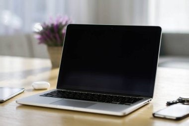 Modern dizüstü bilgisayarı kapat, içi boş ekranlı, güneşli iç döşeme ahşap masa, maketi. İş ve teknoloji kavramı