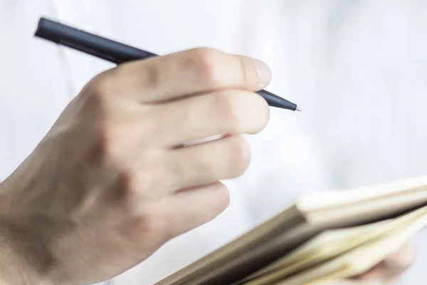 Man Schrijft Staand Met Een Pen Notitieblok Een Zonnig Kantoor — Stockfoto