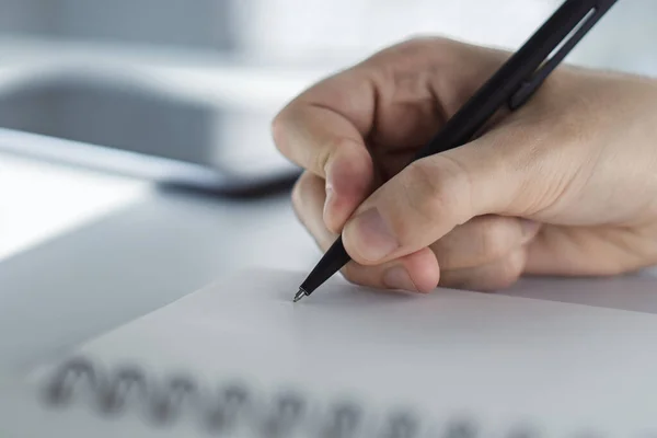 De mens schrijft met een pen in het dagboek in een zonnig kantoor-, bedrijfs- en onderwijsconcept. Sluiten. — Stockfoto