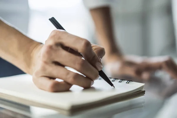 Empresária escreve com uma caneta no diário em um escritório ensolarado, conceito de negócios e educação. Fechar — Fotografia de Stock