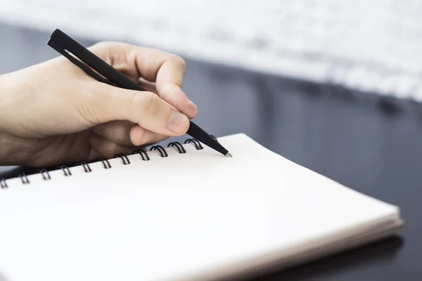 De mens schrijft met een pen in het dagboek in een zonnig kantoor-, bedrijfs- en onderwijsconcept. Sluiten. — Stockfoto
