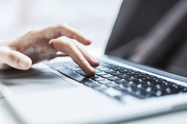 Man typing on laptop keyboard in sunny office, business and technology concept. Close up — Stock Photo, Image