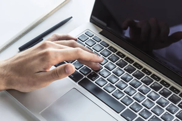 Hombre escribiendo en el teclado del ordenador portátil en la oficina soleada, negocio y concepto de tecnología. De cerca. — Foto de Stock