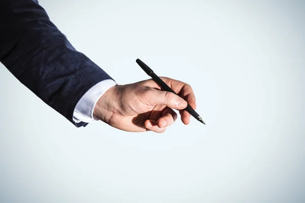 Man hand with pen isolated on blue background, business and education concept. Close up