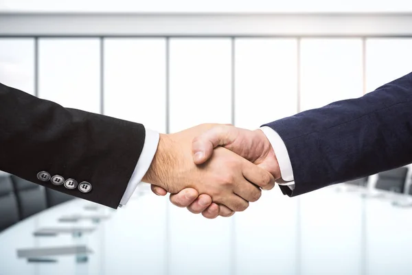 Рукопожатие двух бизнесменов на фоне яркого конференц-зала, концепции партнерства, крупным планом — стоковое фото
