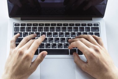 İş adamı, güneşli ofiste dizüstü bilgisayarda klavye kullanıyor, iş ve teknoloji kavramında. Kapat.