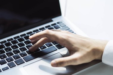 Erkek eller, güneşli ofiste dizüstü bilgisayarda klavye, iş ve teknoloji kavramında daktilo kullanıyor. Kapat.