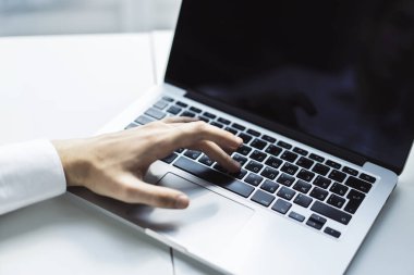 Erkek eller, güneşli ofiste dizüstü bilgisayarda klavye, iş ve teknoloji kavramında daktilo kullanıyor. Kapat.