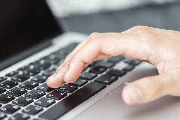 Man hands typing on laptop keyboard in sunny office, business and technology concept. Close up
