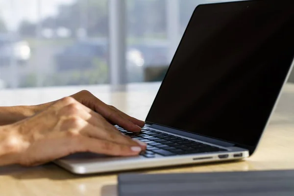 Las manos de la mujer que teclea en el teclado portátil en la oficina soleada, negocio y concepto de tecnología. De cerca. — Foto de Stock