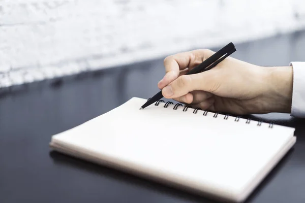 O homem escreve com uma caneta no diário em um escritório ensolarado, conceito de negócios e educação. Fechar — Fotografia de Stock