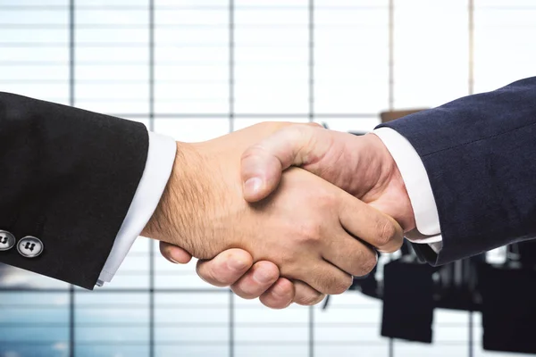Два бизнесмена пожимают друг другу руки на фоне солнечного конференц-зала, сделки концепции, крупным планом — стоковое фото