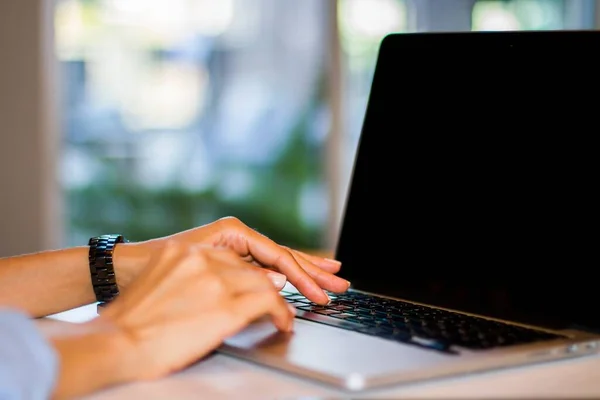 Mujer escribiendo en el teclado del ordenador portátil en la oficina soleada, negocio y concepto de tecnología. De cerca. — Foto de Stock