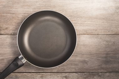 Ahşap kalas üzerinde üst görünüm teflon tava 