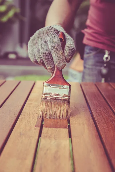 Pincel en mano y pintura sobre la mesa de madera. Retro y v — Foto de Stock