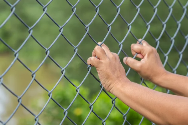 Mano colgando en cerca de eslabones de cadena de metal — Foto de Stock